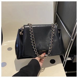 Detail of black leather tote bag with gold chain strap and Fashion & Bags gold lettering
