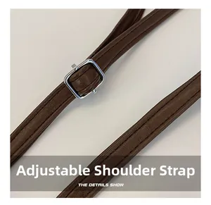 Detail of brown leather strap with silver metal buckle and refined stitching detail