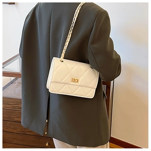 Détail du sac bandoulière matelassé blanc avec fermoir doré et bandoulière en chaîne