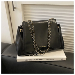 Detail of black flap tote bag with gold FASHION & BAGS lettering and chain strap