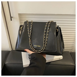 Detail of black tote bag with gold chain strap and FASHION & BAGS logo text