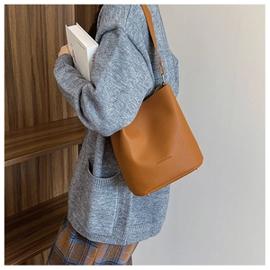 Close-up of caramel brown pebble leather bucket bag with Fashion & Bags embossed logo