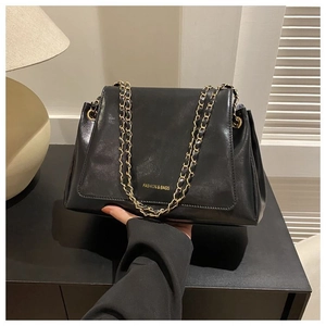 Detail of black leather tote bag with gold chain strap and Fashion & Bags text