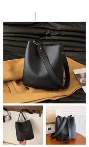 Close-up of black lychee grain leather bucket bag with gold rivets and wide strap