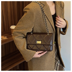 Vue de côté d'un sac matelassé marron foncé avec chaîne et fermoir rotatif doré