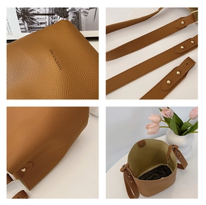 Detail view of brown pebbled leather bucket bag with gold hardware and drawstring insert