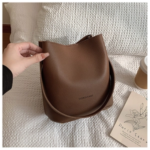 Close-up of brown bucket bag with lychee texture and FASHION & BAGS lettering print