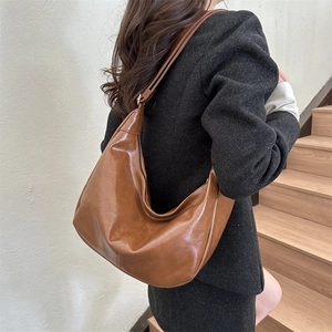 Sac hobo vintage en cuir marron avec bandoulière réglable porté par un mannequin