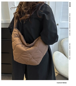 Brown quilted tote bag shown from the back on a model wearing a black jacket