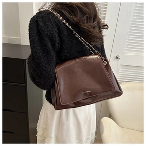 Brown glossy leather tote bag with metal chain strap and gold fashion text detailing