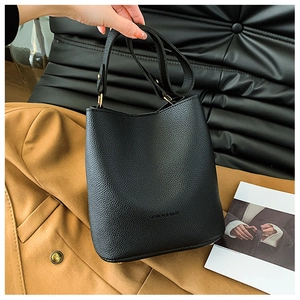 Close-up of black pebbled leather bucket bag with gold hardware and fashion lettering