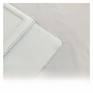 Vue macro d'un sac en cuir blanc montrant une texture fine et des coutures précises