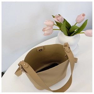 Detailed interior of beige litchi grain bucket bag showing magnetic clasp and texture