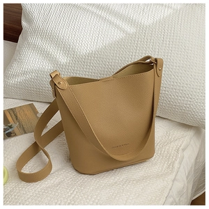 Detail of khaki bucket bag showing litchi texture and fashion logo on leather