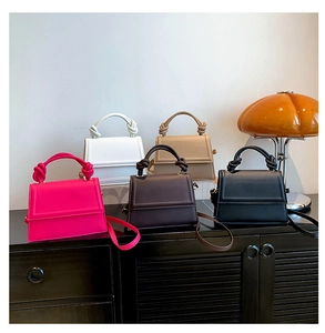 Détail de sacs carrés en cuir en cinq couleurs avec poignée décorative à nœud épais