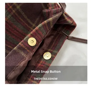 Close-up of golden magnetic closure on Scottish plaid tote bag showing fabric texture