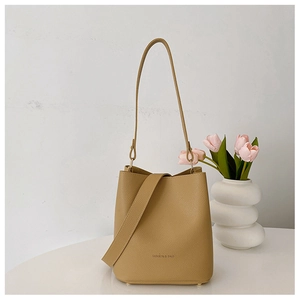 Detailed macro shot of lychee grain leather bucket bag with FASHION & BAGS logo text