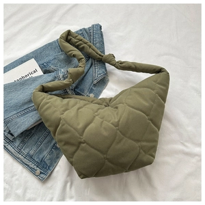 Close-up of olive green quilted puffer bag featuring a knotted shoulder strap detail