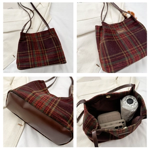 Detail view of plaid tote bag featuring leather base and interior storage capacity