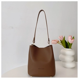 Close-up of a coffee brown litchi pattern leather bucket bag with FASHION & BAGS logo