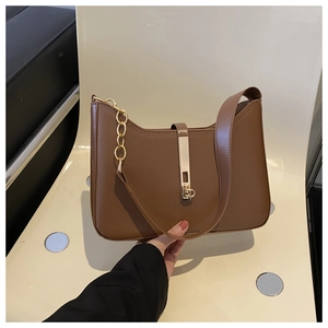 Close-up of vintage brown PU leather bag featuring a gold buckle and chain strap detail