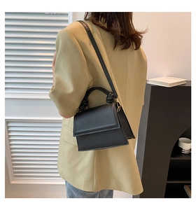 Détail du sac à main en cuir PU noir avec une poignée nouée élégante et une bandoulière