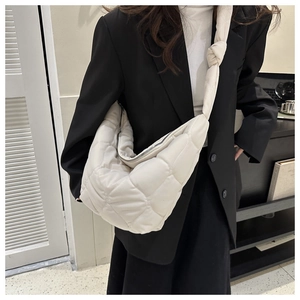 Quilted tote bag in off-white shown on a model with a black blazer for a modern urban look