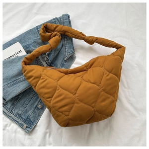 Close-up of caramel quilted nylon bag featuring a knotted strap detail and padded texture