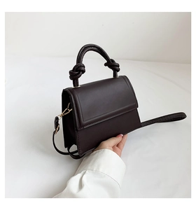 Détail du petit sac bandoulière marron chocolat avec poignée nouée et dorures