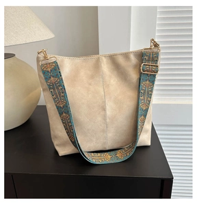 Macro detail of soft cream tote bag featuring a bohemian colorful patterned wide strap