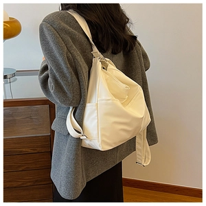 Rear view of model wearing a white large capacity backpack with wide straps and metal buckles