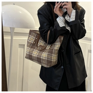 Braune karierte Woll-Tote-Bag, getragen von einem Model mit schwarzer Lederjacke