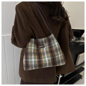 Detail view of the brown and green plaid wool shoulder bag with premium leather straps