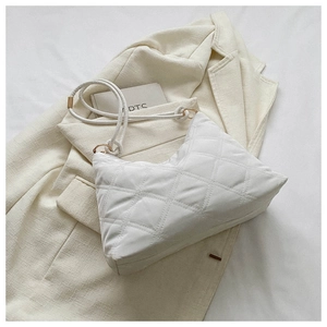 Close-up of white quilted puffer shoulder bag with chunky rope strap and gold rings
