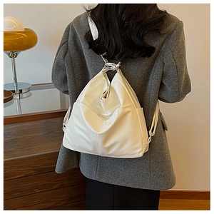 Cream white PU leather bucket tote bag shown worn on shoulder with soft pleated texture