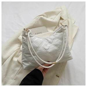 Detail of white quilted crossbody bag with golden hardware and leather strap