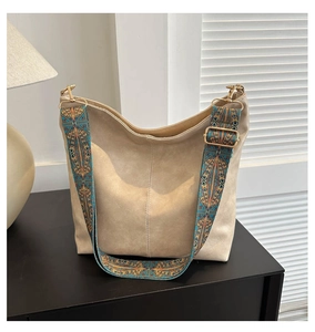 Detail of beige tote bag featuring a colorful bohemian embroidered wide shoulder strap