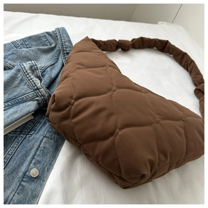 Close-up of brown quilted puffer hobo bag with knotted shoulder strap detail