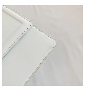 Vue macro des coutures précises et de la texture sur un sac à main blanc