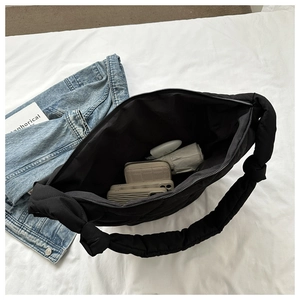 Top view of a black quilted shoulder bag showcasing large interior storage for daily items