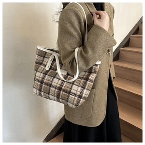 Detaillierte Nahaufnahme von braunem Vintage-Karo-Tweed auf einer stilvollen Umhängetasche