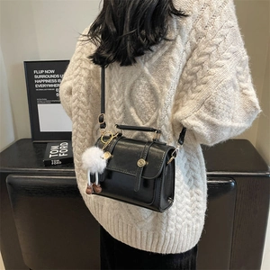 Chic black glossy square crossbody bag with decorative buckles and plush pendant charm