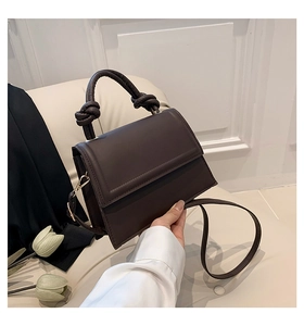 Détails de la poignée nouée et de la texture en cuir mat d'un sac à main marron