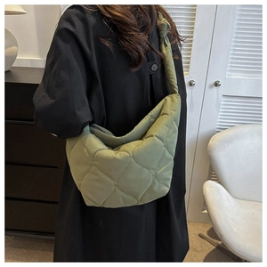 Olive green quilted puffer crossbody bag with decorative knot strap detail on shoulder