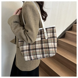 Detail der Vintage-Plaid-Tweed-Einkaufstasche mit Lederriemen und Goldnieten