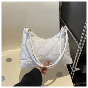 Close-up of white quilted puffer shoulder bag with elegant gold ring hardware details
