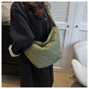 Detail of olive green quilted down shoulder bag with soft cloud-like texture and wide strap