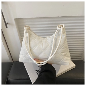 Detail of white quilted crossbody bag with golden hardware and luxury padding