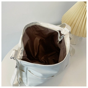 Top view detail of a spacious white tote bag showing the interior compartment and brown lining