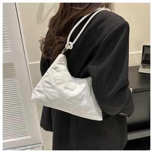 Close-up of white quilted puffer shoulder bag with stylish knotted strap detail